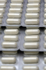 many pills laid out in rows, for background, low contrast, haze