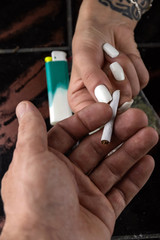 a man's hand gives a woman's hand a cigarette with synthetic marijuana, a sachet with a weed and a...