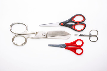 scissors for different purposes and sizes on a white background, vintage and new, plastic and metal