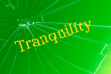 The text tranquility on the broken glass. Disorder or interfering concept.