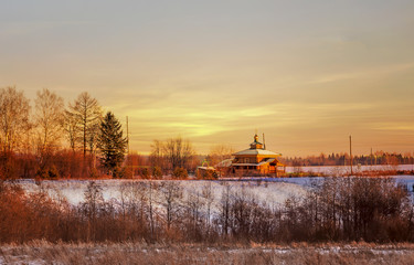 Obraz premium Bright sunset is yellow - the sun, red with a lilac shade, in the remote village in a midland of Russia.