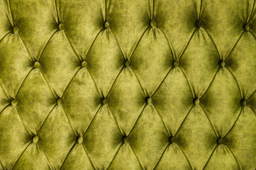 Velor lime surface of sofa close-up. Training equipment-velor mats tightened with buttons. Yellow chesterfield style quilted upholstery background