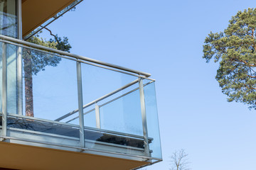 Furnished balcony of the house in the forest on the background of blue sky