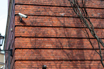 Two Video surveillance camera on location on background blue sky
