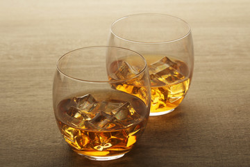 Two glasses with whiskey with ice cubes