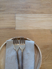 Tissue with two fork brass on brown rustic wooden table  top view from above with copy space