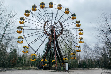 Abandoned carousel and abandoned ferris at an amusement park in the center of the city of Pripyat,...