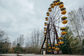 Abandoned carousel and abandoned ferris at an amusement park in the center of the city of Pripyat,...