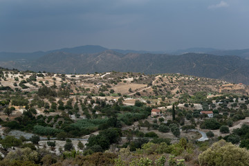 Aerial view of small beautiful village. View of mountains and storm clouds. Summer.