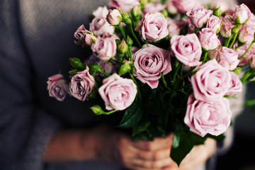 Woman hands hold rose flowers. Blogger girl holding a bunch of flowers. Blogging concept.  
