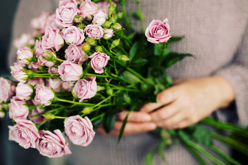 Woman hands hold rose flowers. Blogger girl holding a bunch of flowers. Blogging concept.  