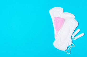 menstrual   cup,pad, tampon on a blue background.