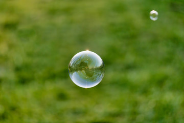 Lonely Colorful Soap Bubble with Reflection of the City and Sky Inside It
