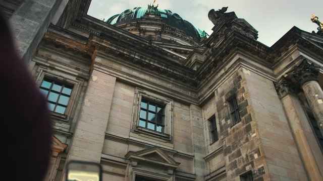 young girl photographs on a smartphone a medieval landmark. Slow Motion.