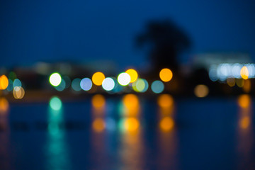 Beautiful blurred city lights with bokeh effect reflected on water
