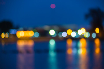 Beautiful blurred city lights with bokeh effect reflected on water