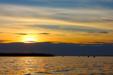 Silhouette of kayaks in the lake at sunset. Kayaking at sunset in the calm lake at autumn
