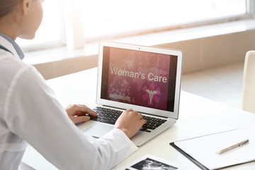 Young gynecologist with laptop working in her office