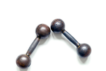Two metal brutal dumbbells on a white background, top view close-up.
