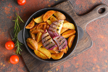 Frying pan with tasty baked potato on table