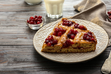 Plate with piece of tasty cranberry pie on table