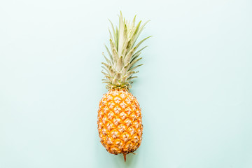 Fresh pineapple lying on blue background. Top view. Flat lay concept
