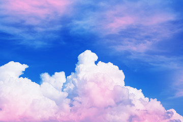 Blue sky with white and pink clouds on a Sunny summer day. Natural background.