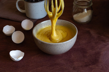 The process of making the cake. Bowl with dough for the pie and whisk. Close-up