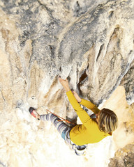 The girl climbs the rock. Fitness in nature and rock climbing. The climber climbs up.