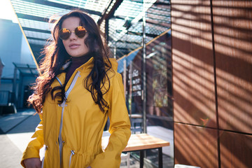  young woman in yellow raincoat at city street