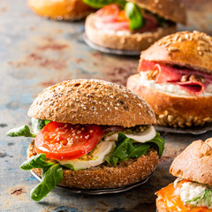 Italian Caprese sandwiches with fresh tomatoes, mozzarella cheese and lamb's lettuce, multigrain bun. Healthy lunch concept with copy space