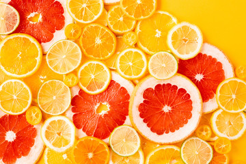 Juicy fresh bright summer yellow background with citrus fruits, flat lay. Sliced mixed citrus fruits, concept of healthy eating, detox, dieting, top view and flatlay.