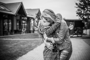 Family relationship concept. Woman during the city with the little adorable girl at street outdoors. Mother and daughter 