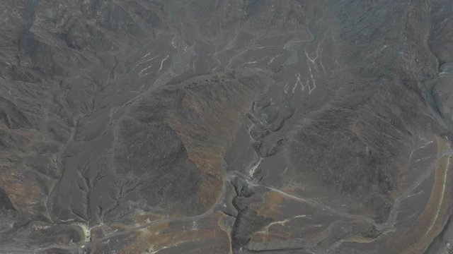 Aerial bird's eye view of a mountain revealing the sunrise.
