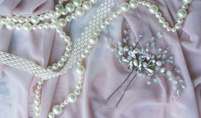 Wedding background with pearls and hair accessories on pink background