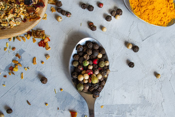 Metal spoon with spice. Fragrant seasoning of pepper mixtures on the original background. Close-up, flat lay, top view