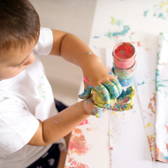 child draws paints fingers