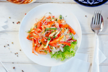 Achik-chukchuk salad with tomatoes and onion at white plate, top view.