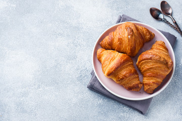 Breakfast croissants on a plate and a Cup of coffee on the table, copy space.