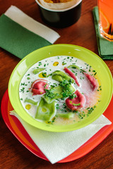 Green and red ravioli in soup for kids.