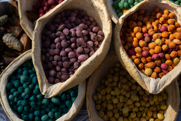 Purple, lilac, orange, green, yellow, red cherry stones  in a two cold yellow basket made of hand-made of dump