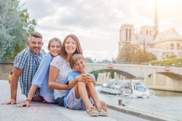 Happy family having fun near Notre-Dame cathedral in Paris. Tourists enjoying their vacation in France. - 262967681