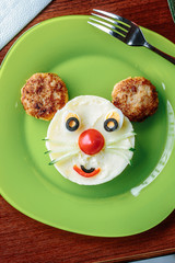 Top view of kid food - funny face made from potato puree and meat.