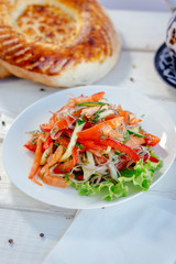 Vegetable salad on the white plate. Achik Chukchuk salad with tomatoes and onion.