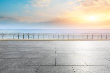 Empty square floor and blue sea with sky clouds at sunset