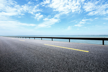 Empty asphalt road and sea with beautiful clouds