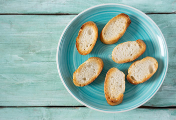 toasted baguette slices on turquoise surface