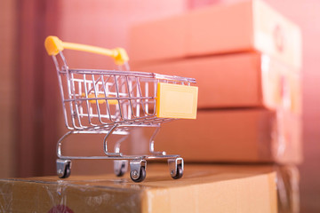 mini yellow shopping cart with cardboard boxes in background