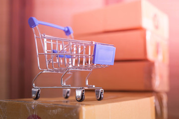 mini blue shopping cart with cardboard boxes in background