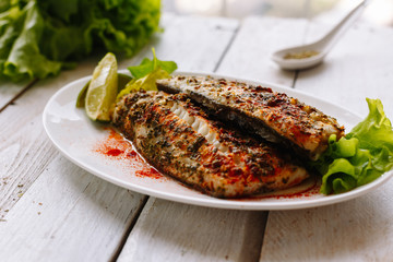 Baked fish wild spicy spices and lime. Wooden white table. Diet. Dinner. Homemade.